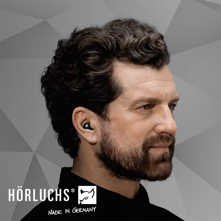 Mann mit maßgefertigtem Gehörschutz im Ohr