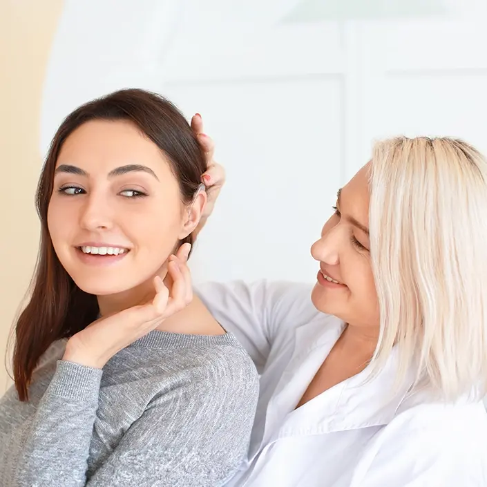 Akustikerin mit einer Kundin bei der Hörgeräteanpassung